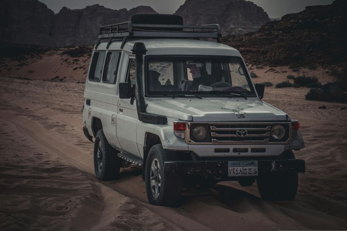 A scenic road stretching through Egypt’s desert landscape with vast sand dunes and a clear blue sky